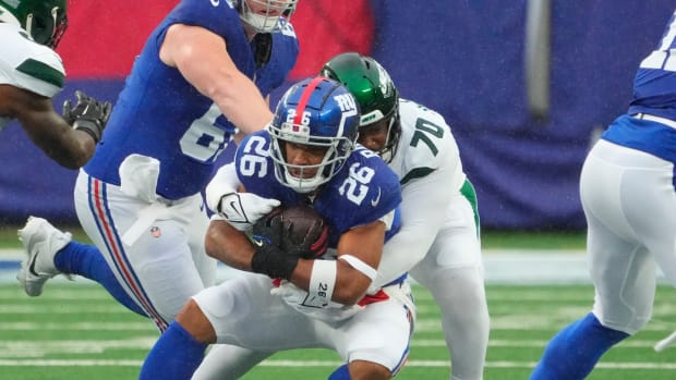 Oct 29, 2023; East Rutherford, New Jersey, USA; New York Jets defensive tackle Quinton Jefferson (70) stops New York Giants running back Saquon Barkley (26) in the first half at MetLife Stadium. Mandatory Credit: Robert Deutsch-USA TODAY Sports